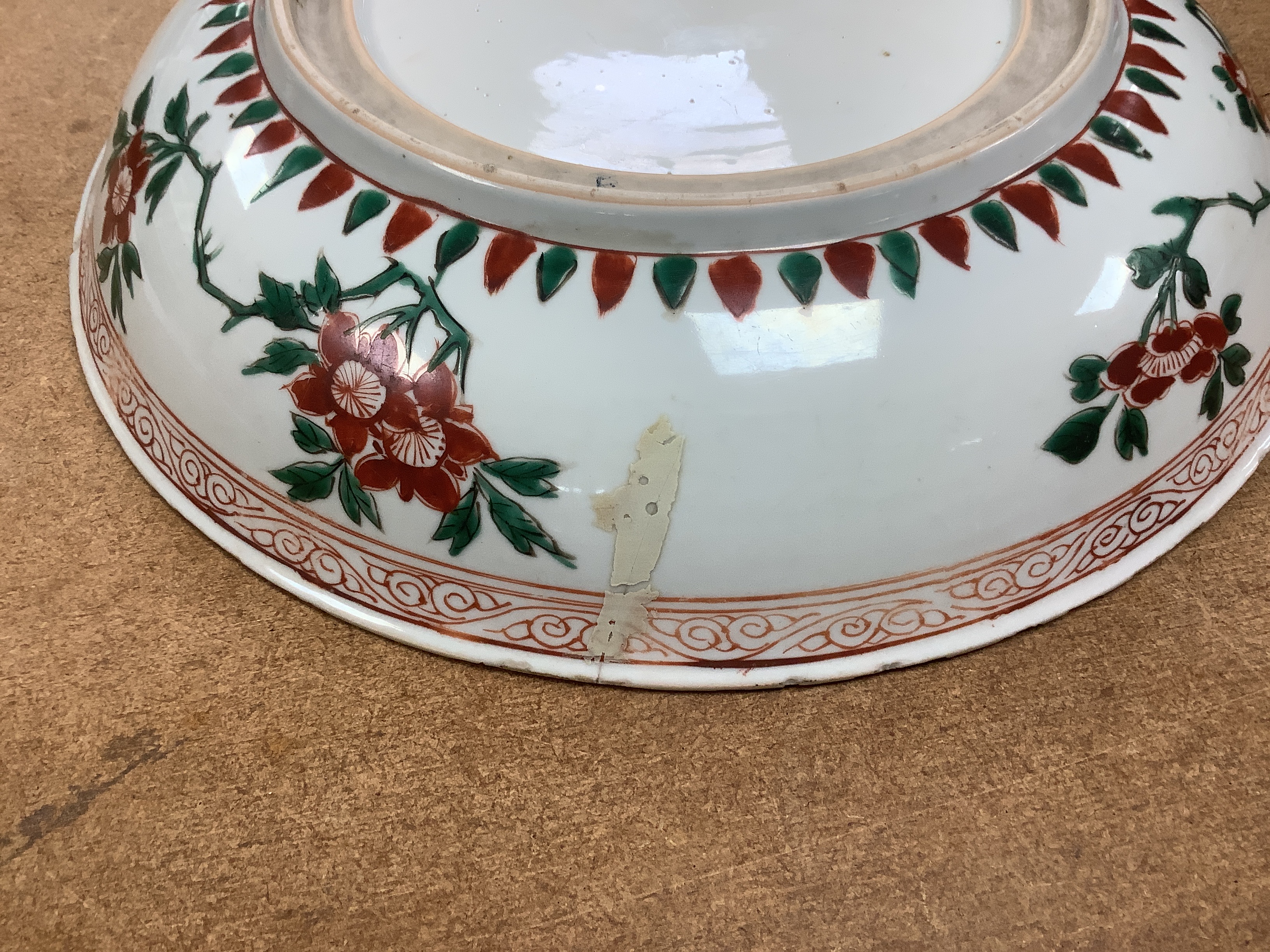 A Chinese famille verte dish, Kangxi period, decorated with flowers bands of brocade patterns, channel moulded foot, 33cm diameter